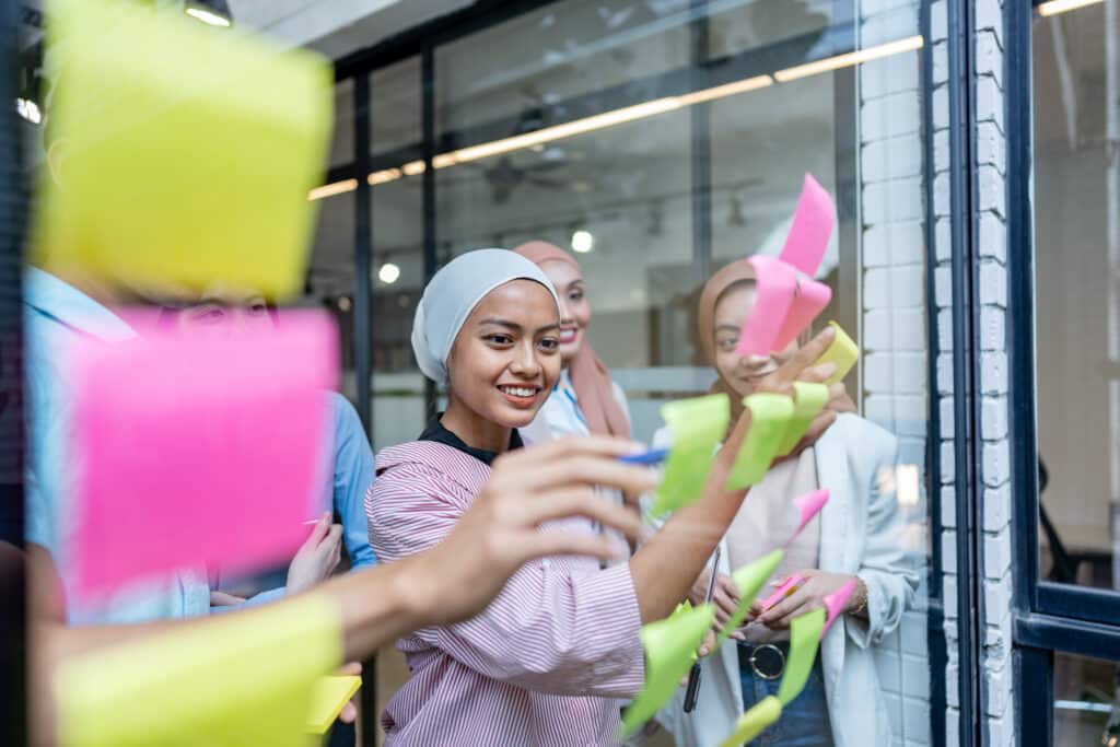 Using post-it notes on glass walls to write strategic business plans in office