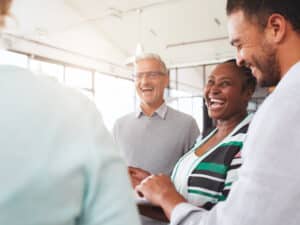 Laughing group of diverse businesspeople going over paperwork together
