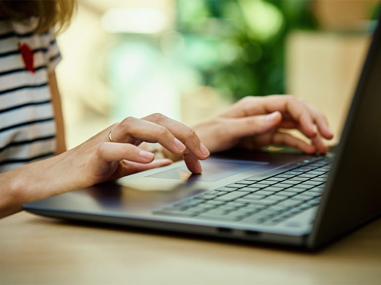 Close up of woman using mouse on laptop