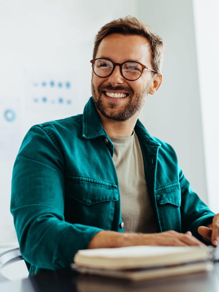 Happy business man listening to a discussion in an office