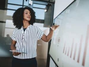 Detail_Woman presenting ideas via graphs on screen_GettyImages-1605948100
