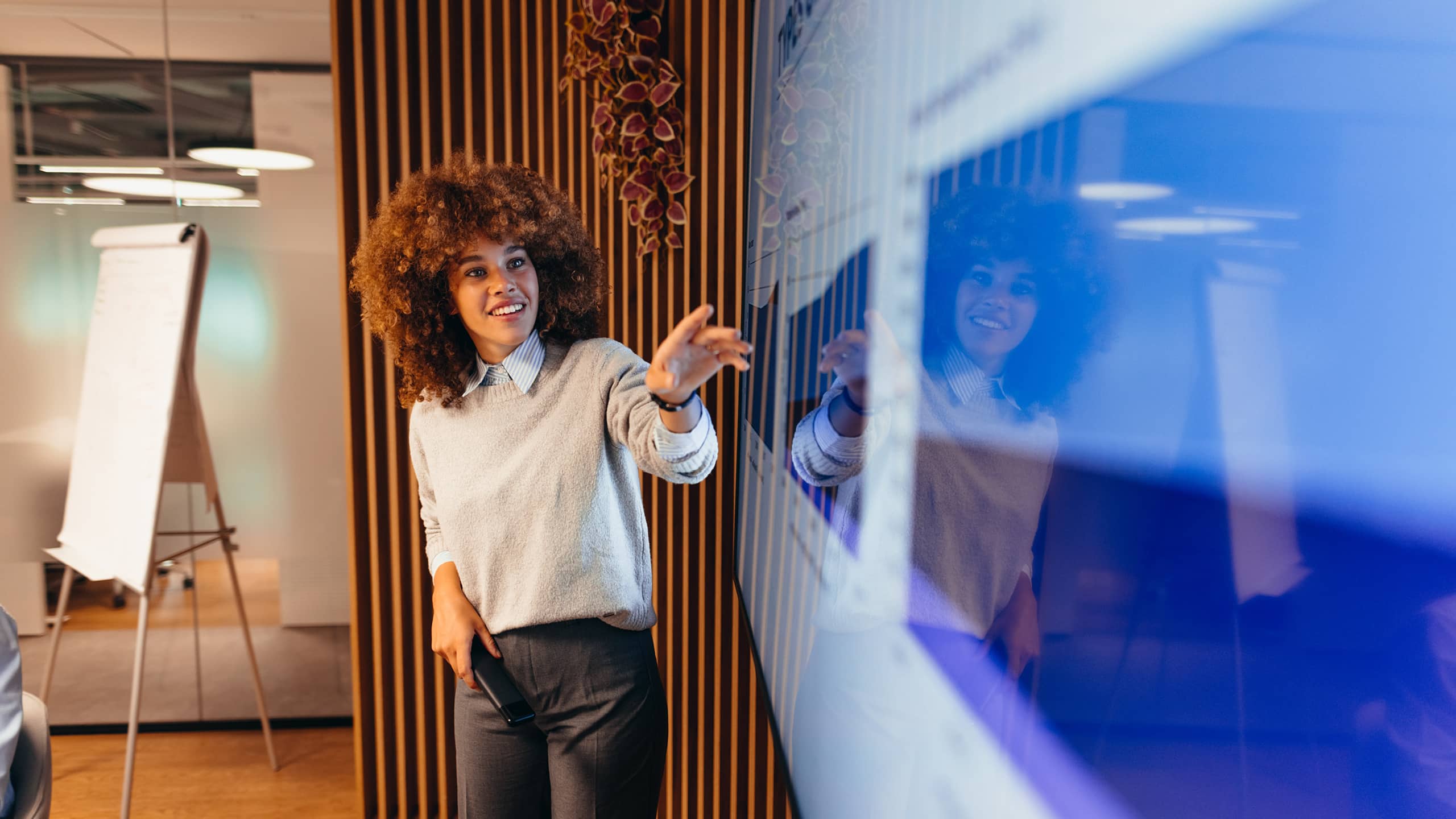 Young businesswoman pointing at monitor during a presentation in the office