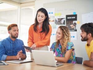 Shot of a group of young businesspeople using a laptop and digital tablet in a modern office
