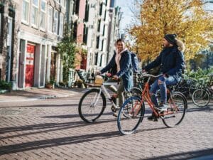 People enjoying the city break in late autumn or early winter in sunny Amsterdam